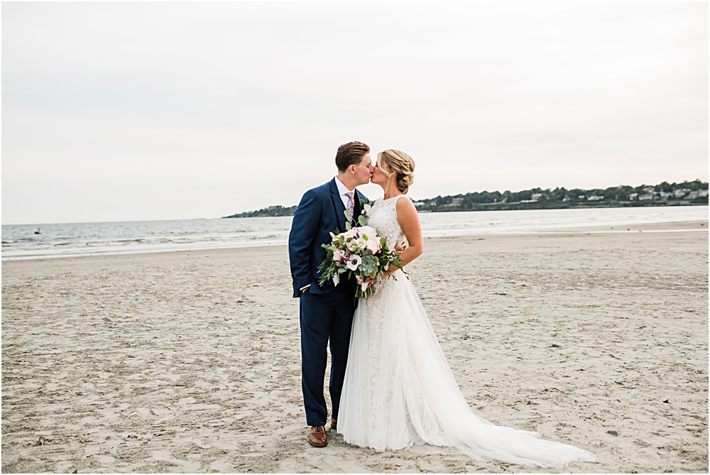 bride and groom kiss on the beach