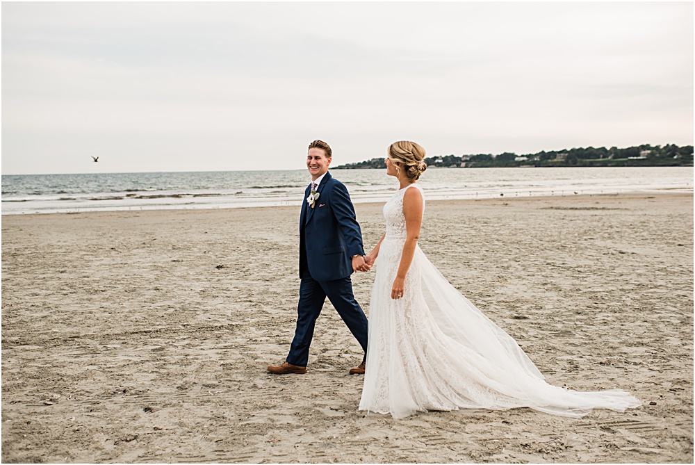 bride and groom walk on beach