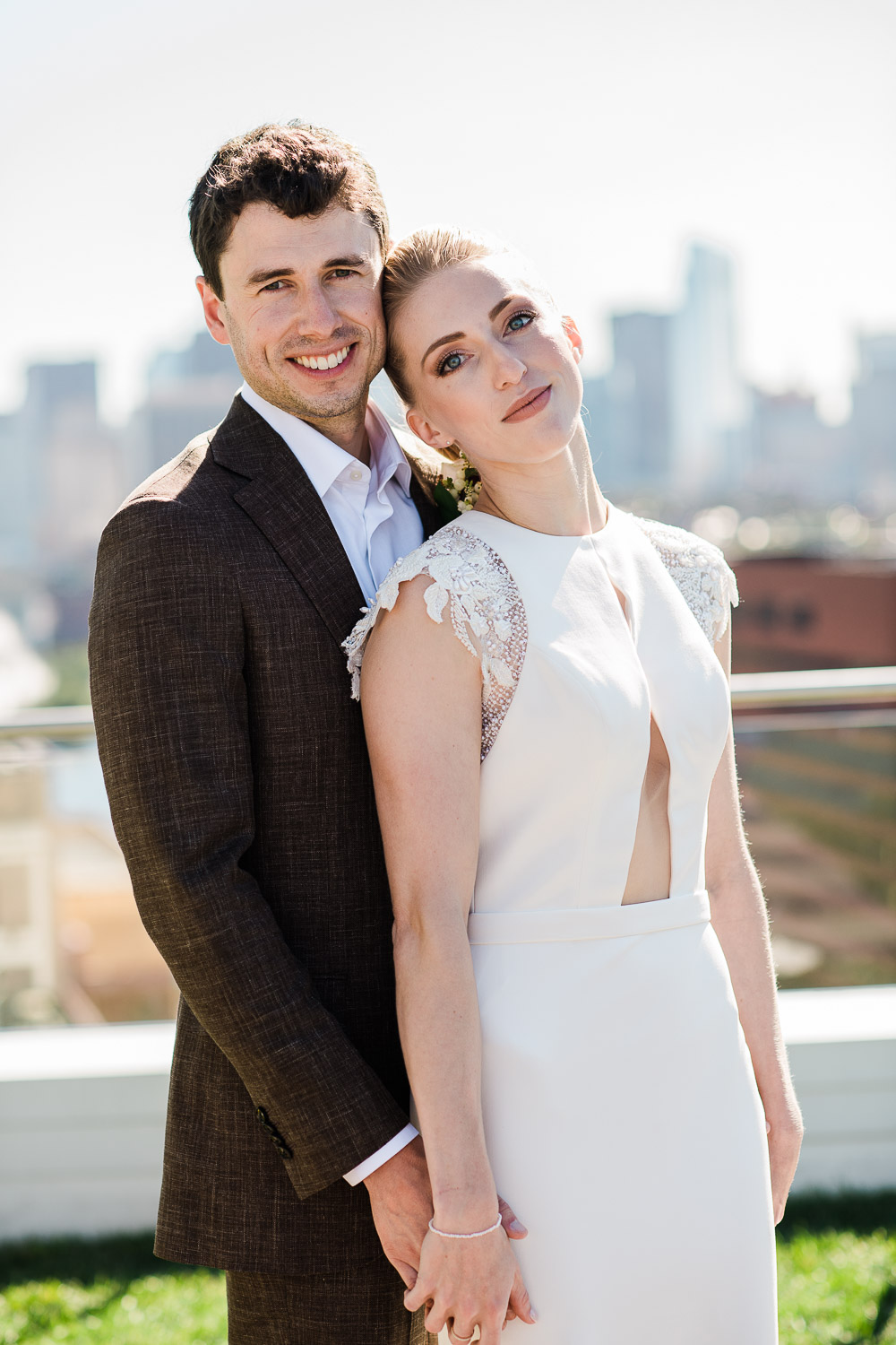 informal bride and groom portrait on rooftop overlooking Boston skyline at the Watermark Kendall Hotel