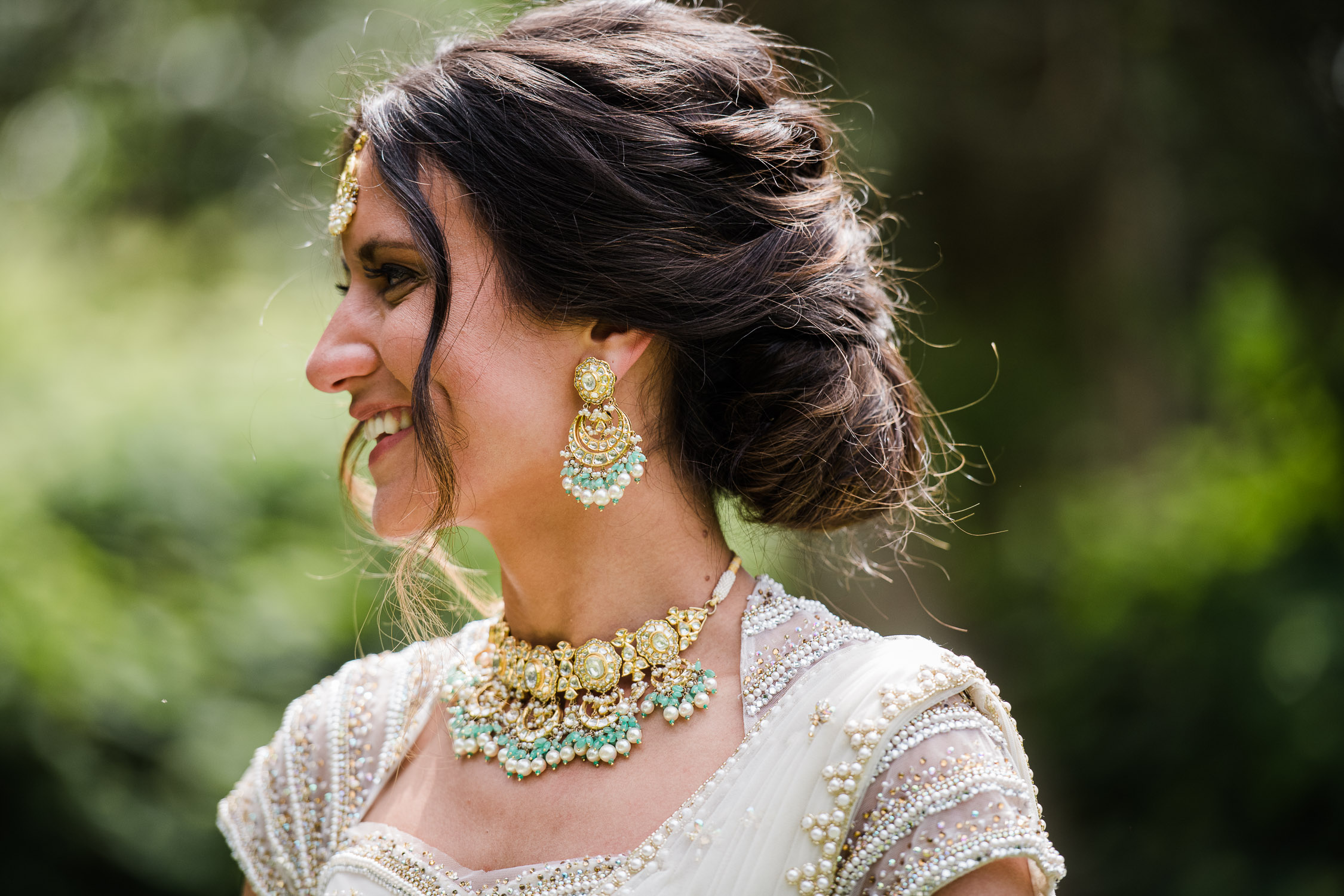profile of Indian bride wearing elaborate turquoise and gold necklace and earrings at Castle Hill Inn in Newport RI