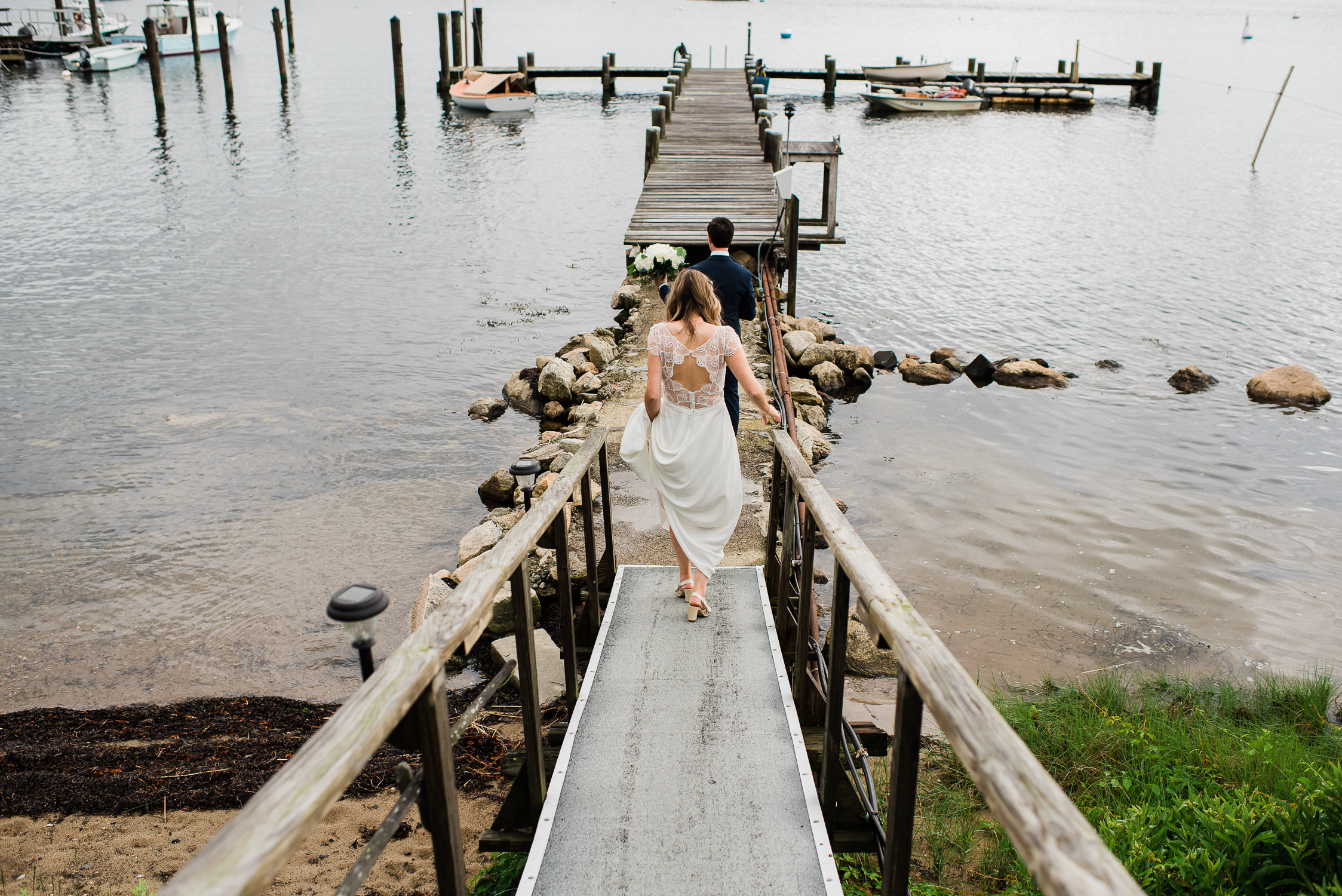 bride and groom walking on a dock from behind in Noank Connecticut