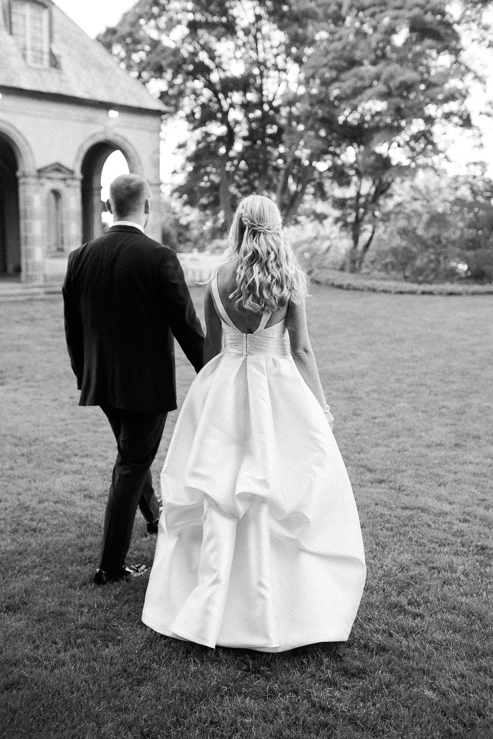 bride and groom walking away in garden of Glen Manor House