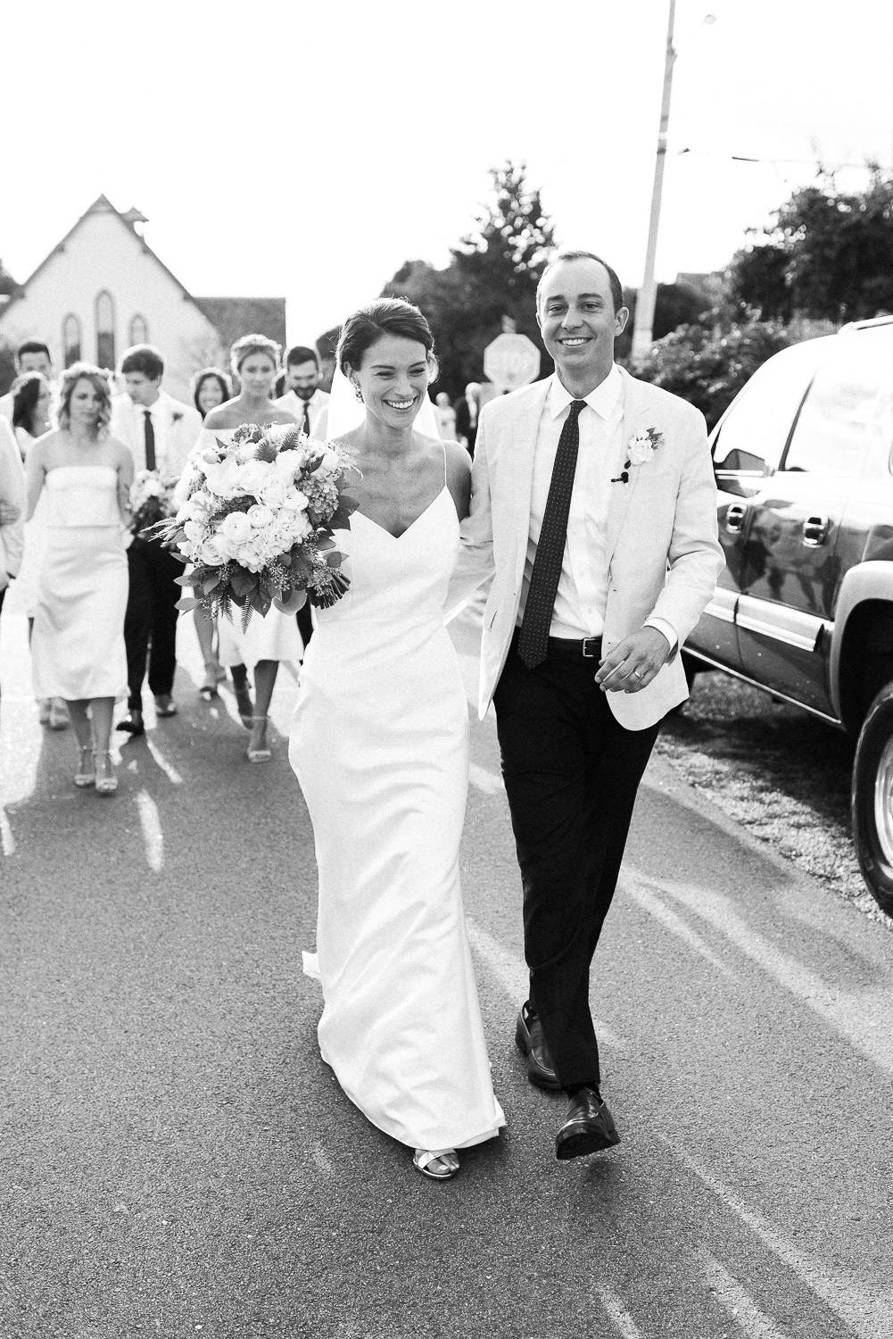 bride and groom walking with wedding party from the Weekapaug Chapel to the Weekapaug Inn