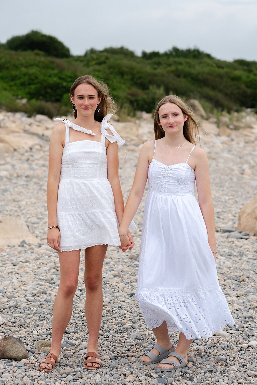 Sisters holding hands on rocky Narragansett coastline