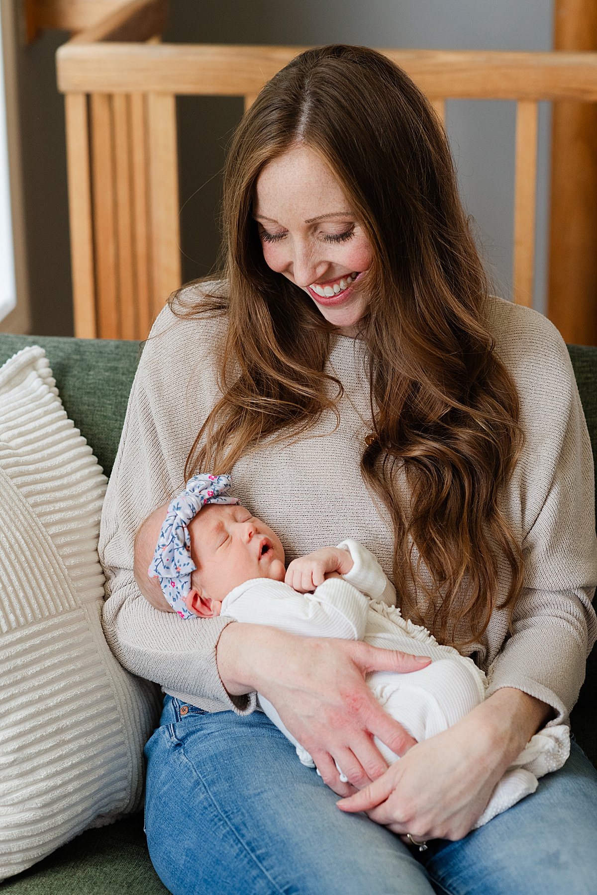 mom looks lovingly at her newborn daughter as she holds her in her arms