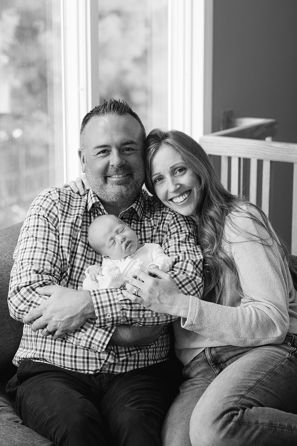indoor portrait of parents and newborn baby girl