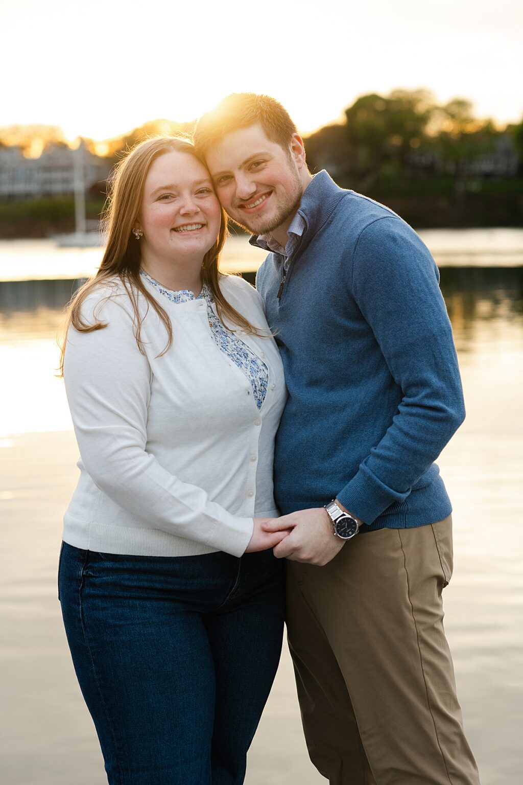 golden hour portrait of engaged couple by the water