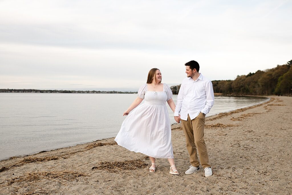 couple standing on the beach looking at each other