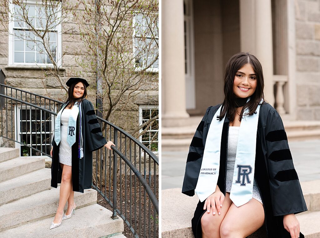 URI graduate wearing cap and gown and cords leaning against a railing