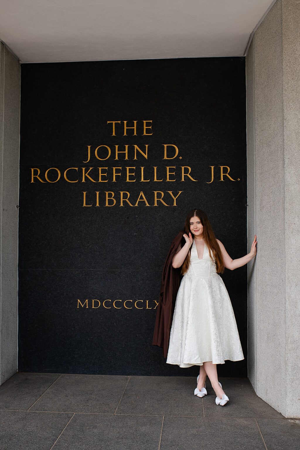Portrait of a graduate in front of the university library
