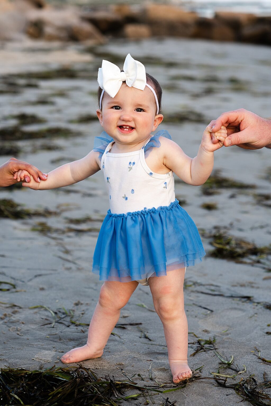 Little girl with a large bow smiling during family portraits